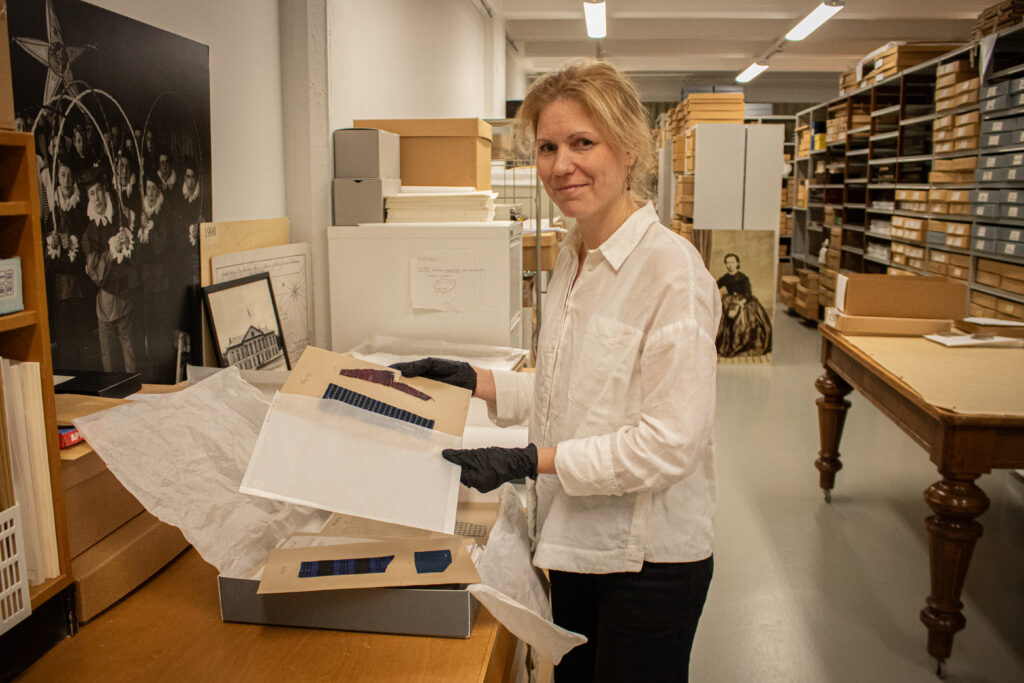 Paula Schuth pakkaamassa tekstiilinäytteitä museon kokoelmatiloissa.
