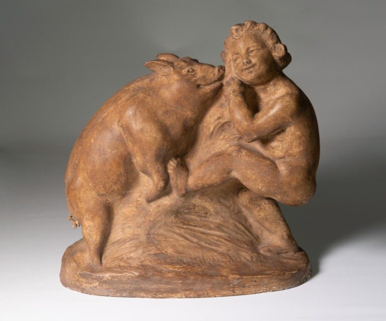 Statyett i färgad gips föreställande gosse lekande med en gris.