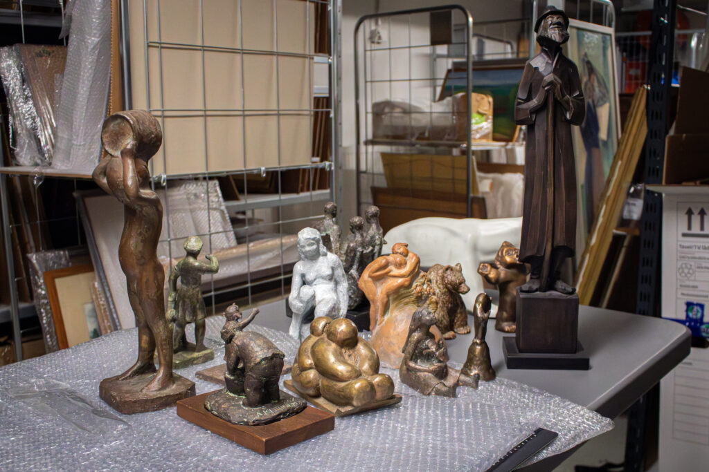 Pöydälle on aseteltu muutamia eri materiaaleista valmistettuja veistoksia.