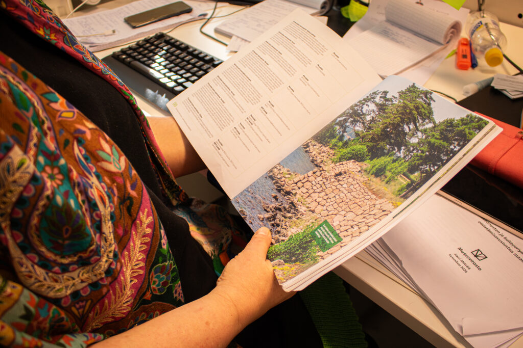 Lähikuva kirjasta, jota Lehtinen pitää käsissään.